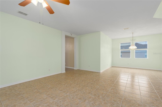 unfurnished room with light tile patterned floors, visible vents, baseboards, and ceiling fan with notable chandelier