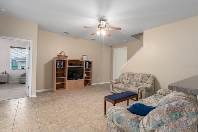 living area featuring light tile patterned floors, baseboards, visible vents, and ceiling fan