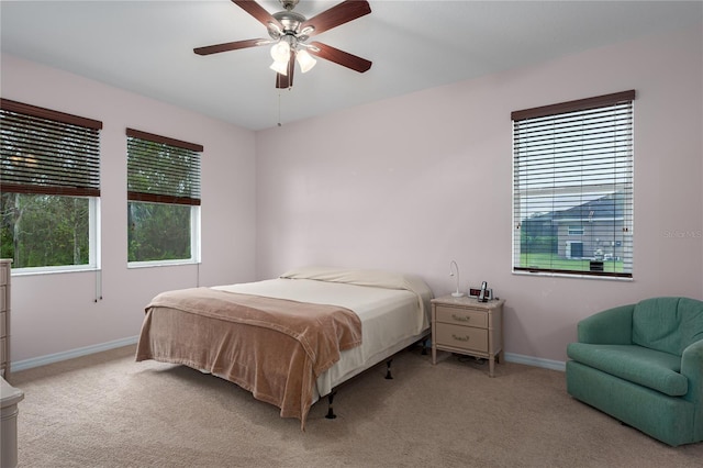 bedroom with baseboards, multiple windows, and carpet