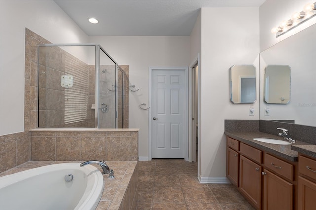 full bathroom featuring baseboards, a stall shower, vanity, and a garden tub