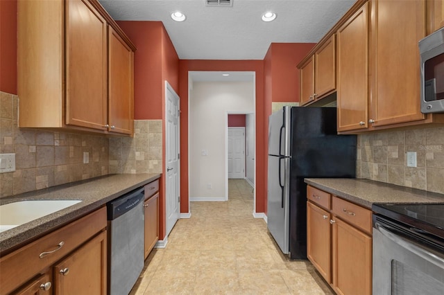 5412 72nd Ter E, Ellenton, FL 34222 - kitchen with stainless steel appliances, dark countertops, baseboards, brown cabinetry, and recessed lighting