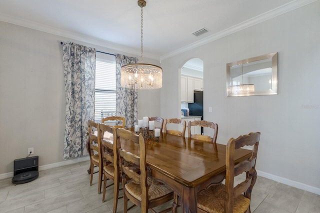 dining room featuring an inviting chandelier, baseboards, visible vents, and ornamental molding