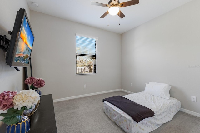 carpeted bedroom featuring baseboards and ceiling fan