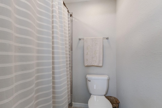 bathroom with curtained shower and toilet