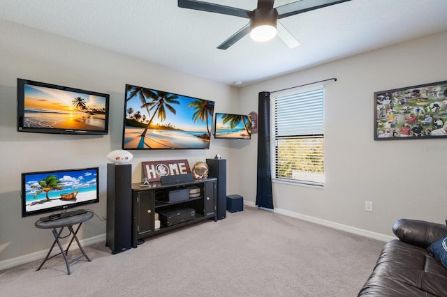 living area with baseboards, light carpet, and ceiling fan