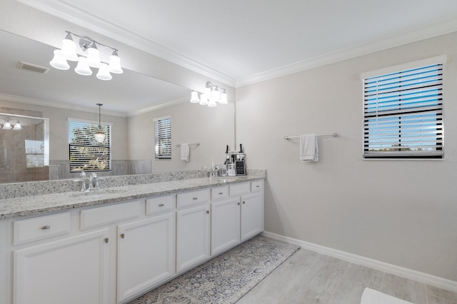 full bath featuring visible vents, a tile shower, a sink, crown molding, and a notable chandelier