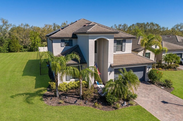 traditional home with decorative driveway, a garage, a front yard, and a tiled roof