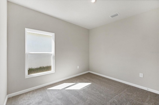 carpeted empty room featuring baseboards and visible vents