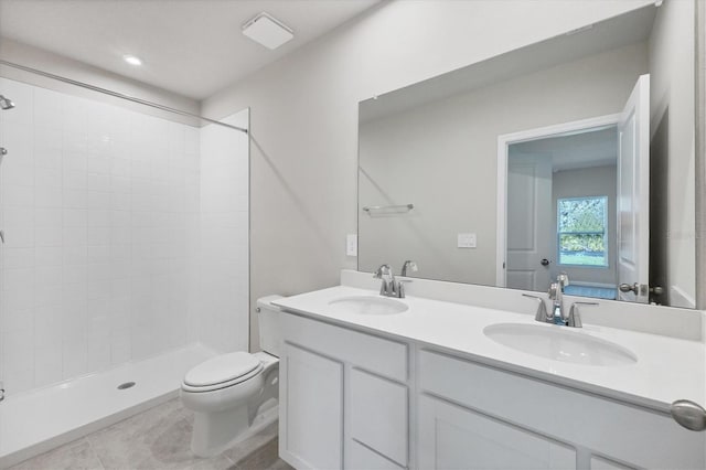 full bathroom featuring a sink, toilet, a shower stall, and double vanity