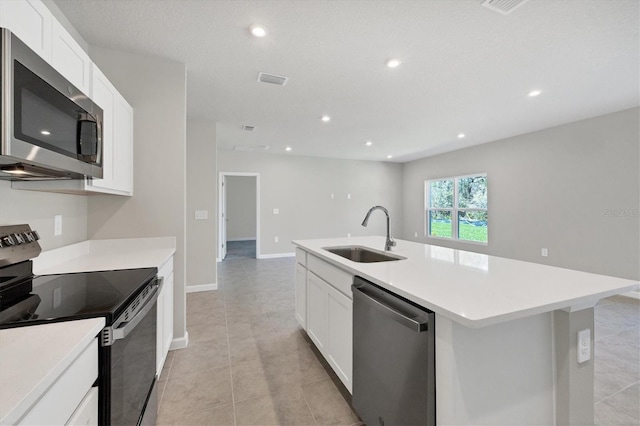 kitchen featuring light countertops, recessed lighting, appliances with stainless steel finishes, white cabinetry, and a sink