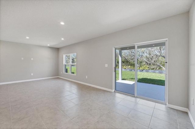 empty room featuring recessed lighting, baseboards, and light tile patterned floors