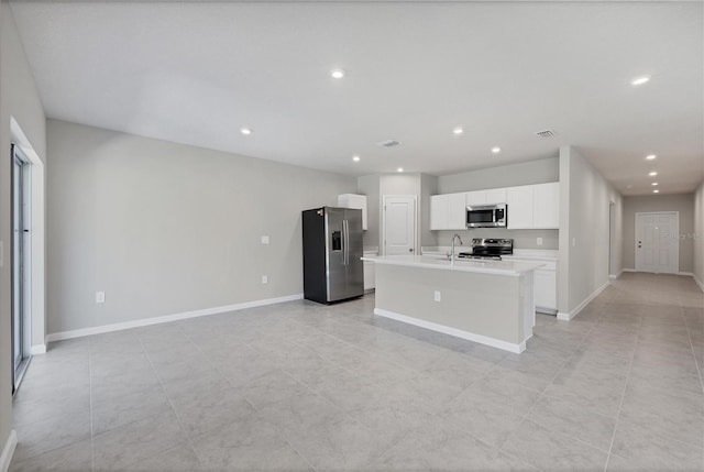 kitchen featuring a kitchen island with sink, white cabinetry, appliances with stainless steel finishes, light countertops, and baseboards