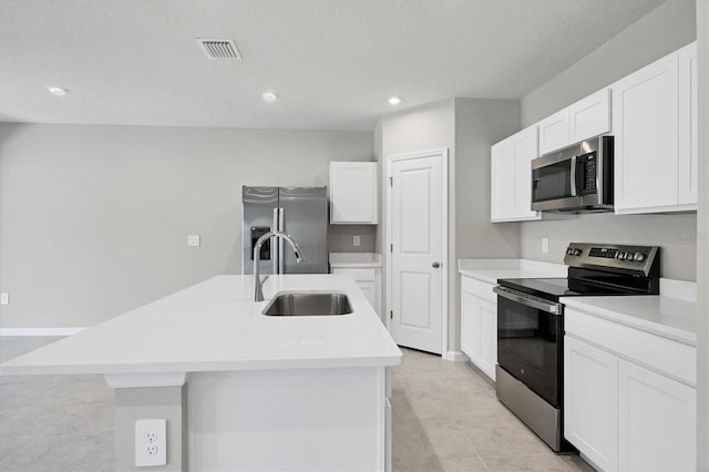 kitchen with a center island with sink, appliances with stainless steel finishes, white cabinetry, and a sink