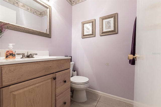 half bathroom featuring tile patterned floors, toilet, vanity, and baseboards