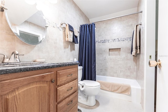 full bath with tile patterned floors, toilet, shower / tub combo with curtain, tile walls, and vanity