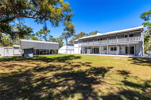 back of property with a yard and a balcony