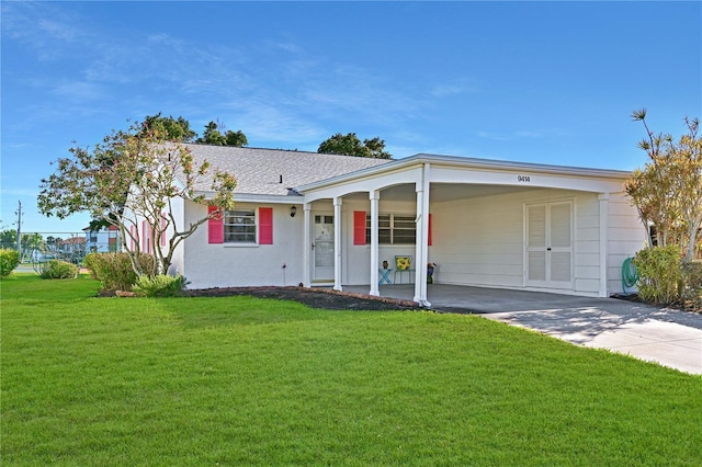 ranch-style home featuring concrete driveway, a front yard, and a shingled roof