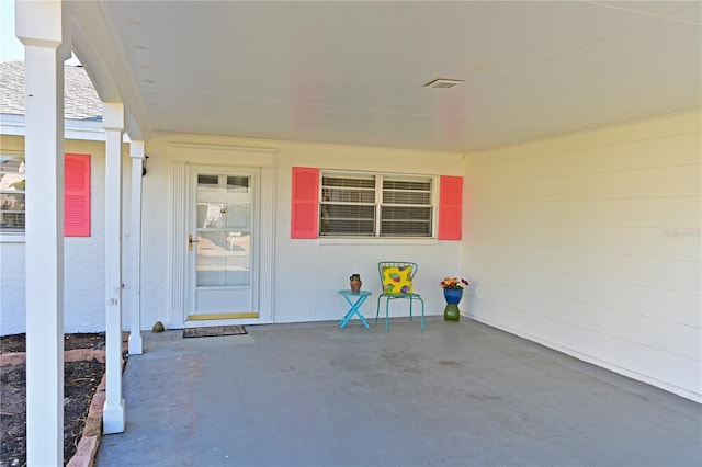 entrance to property featuring a patio area and stucco siding