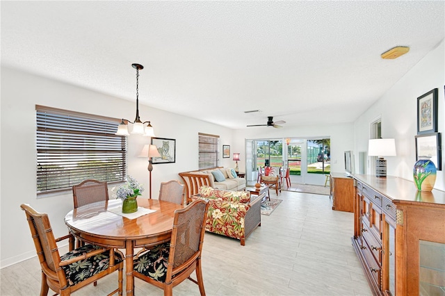 dining room featuring ceiling fan, light wood-style floors, and a textured ceiling