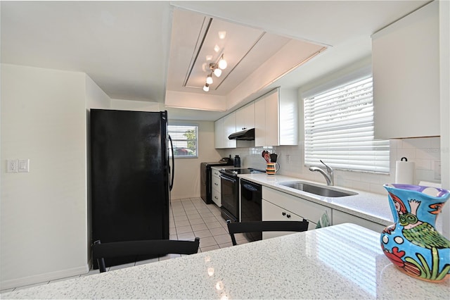 kitchen featuring black appliances, a sink, under cabinet range hood, tasteful backsplash, and white cabinetry