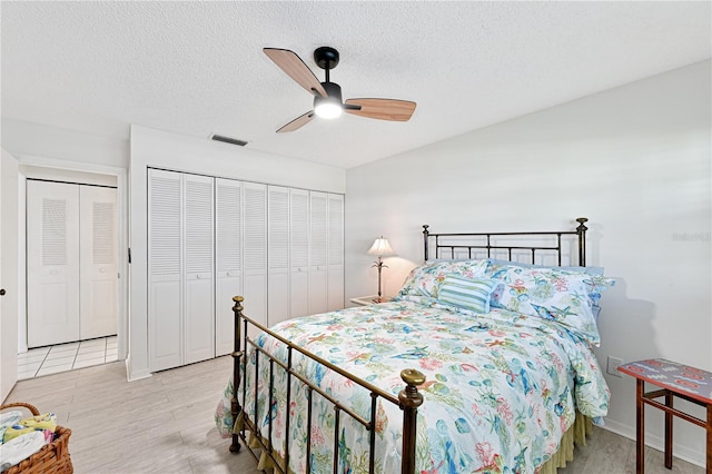 bedroom with a closet, visible vents, a textured ceiling, and a ceiling fan