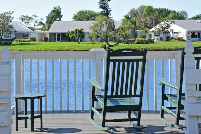 dock area featuring a residential view, a yard, and a water view