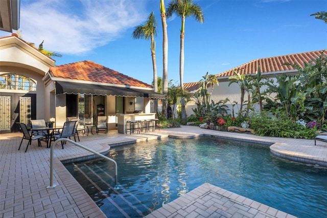 pool featuring a patio and outdoor dry bar