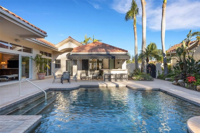 view of pool with a patio area, a fenced in pool, outdoor dry bar, and fence