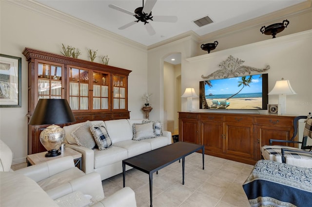 living area featuring visible vents, ornamental molding, arched walkways, light tile patterned floors, and ceiling fan