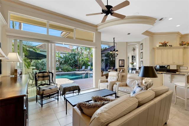 living area with light tile patterned floors, visible vents, and crown molding