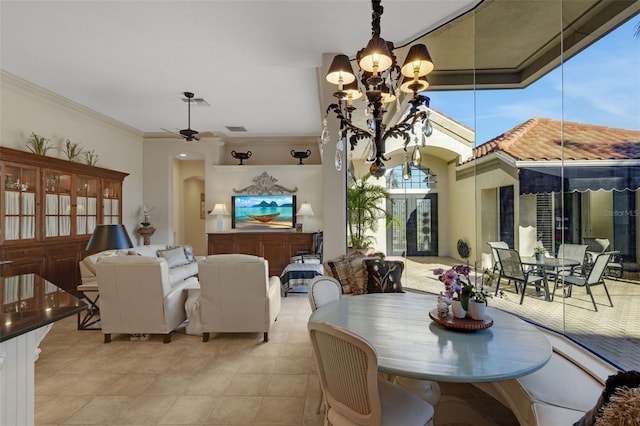 tiled dining space with arched walkways, crown molding, and ceiling fan with notable chandelier