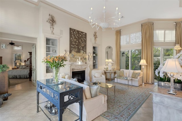 living room with built in shelves, a high ceiling, a fireplace, and crown molding