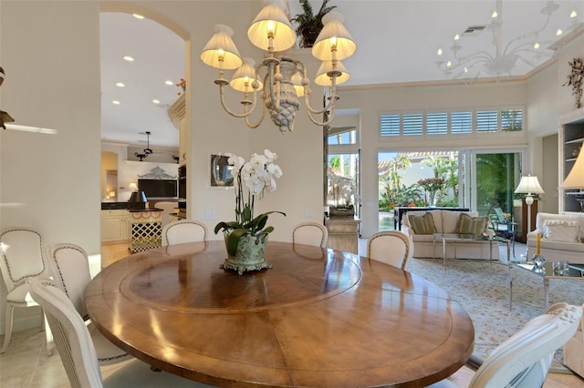 dining room featuring recessed lighting, arched walkways, crown molding, a chandelier, and a towering ceiling