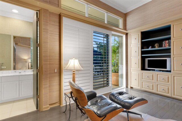 sitting room featuring wood finished floors and crown molding