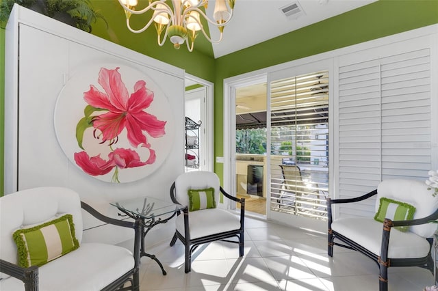 living area featuring a notable chandelier, light tile patterned flooring, and visible vents