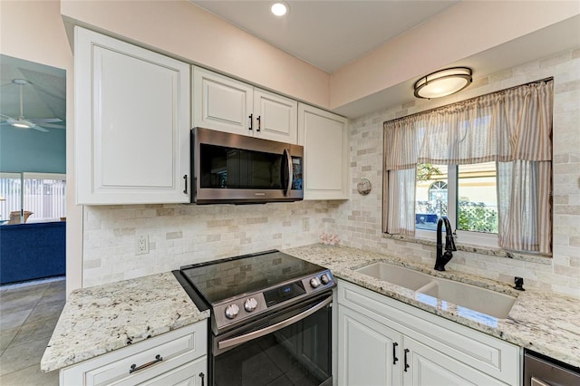 kitchen with decorative backsplash, appliances with stainless steel finishes, plenty of natural light, a ceiling fan, and a sink