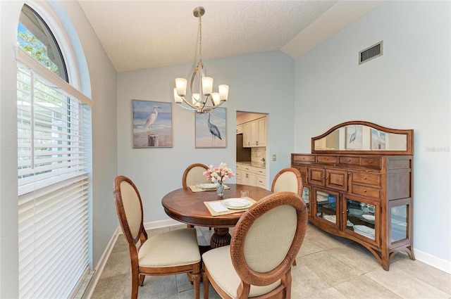 dining space with vaulted ceiling, a notable chandelier, visible vents, and plenty of natural light