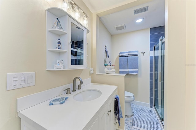 bathroom featuring vanity, a shower with shower door, baseboards, visible vents, and toilet