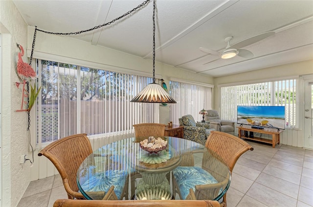 dining area featuring ceiling fan, a textured ceiling, light tile patterned flooring, and a textured wall