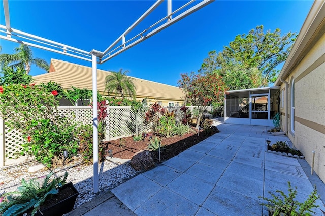 view of patio / terrace with fence and a sunroom