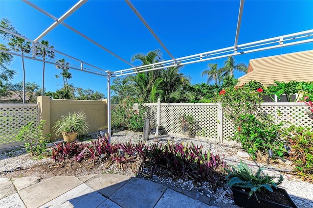 view of patio / terrace featuring glass enclosure and fence