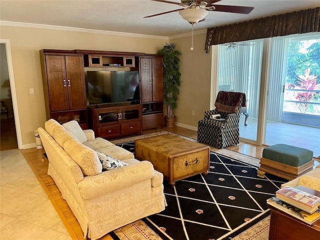 living area with light tile patterned flooring, a ceiling fan, baseboards, and ornamental molding