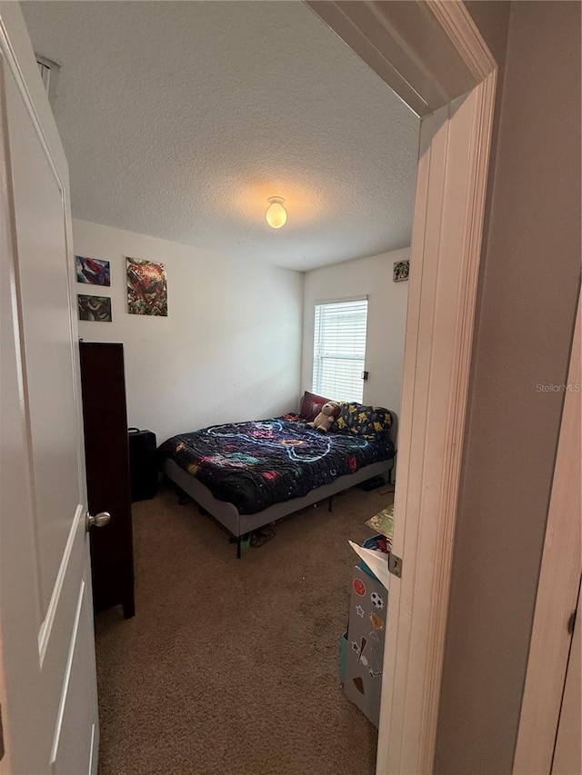 carpeted bedroom with a textured ceiling