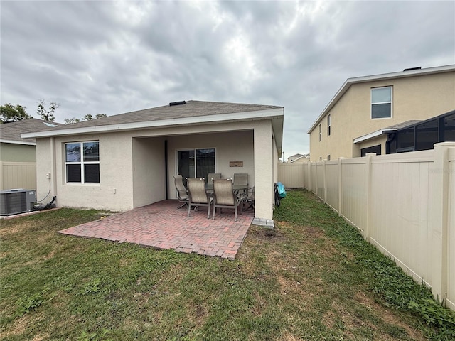 back of property featuring a yard, stucco siding, central air condition unit, a patio area, and a fenced backyard