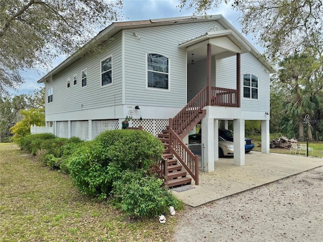 view of front facade with stairway, a carport, and driveway