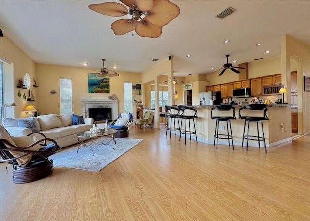 living room with visible vents, recessed lighting, a fireplace, ceiling fan, and light wood-type flooring