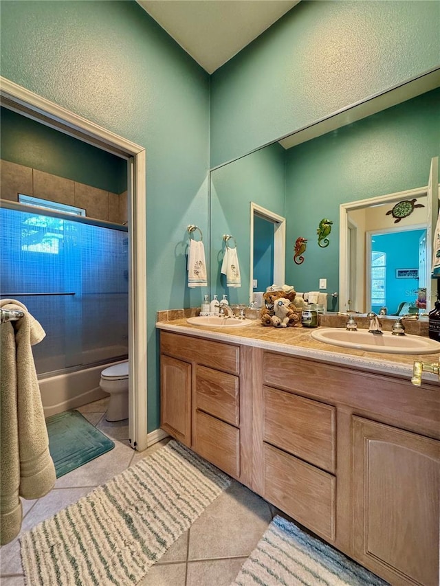 full bath with tile patterned floors, double vanity, and a sink