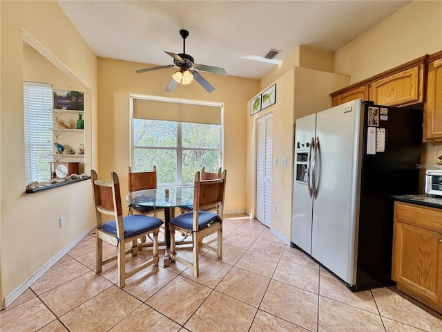 dining area featuring light tile patterned floors, a ceiling fan, visible vents, and baseboards