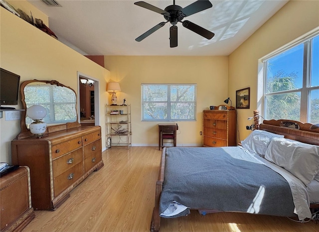 bedroom featuring light wood finished floors, a ceiling fan, and baseboards