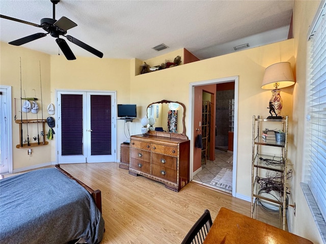 bedroom featuring ceiling fan, visible vents, a textured ceiling, and wood finished floors